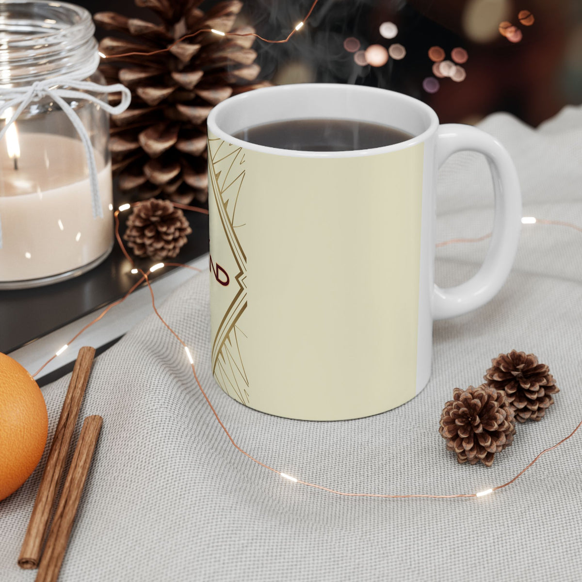 White mug with 'Heir' text on a table with decorative items