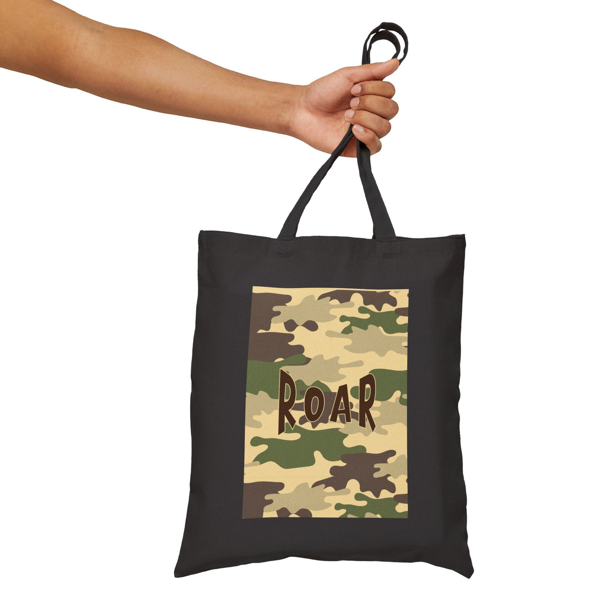 A black canvas tote bag with a camouflage print panel featuring the word 'ROAR' in brown letters, held by a person's hand against a white background.
