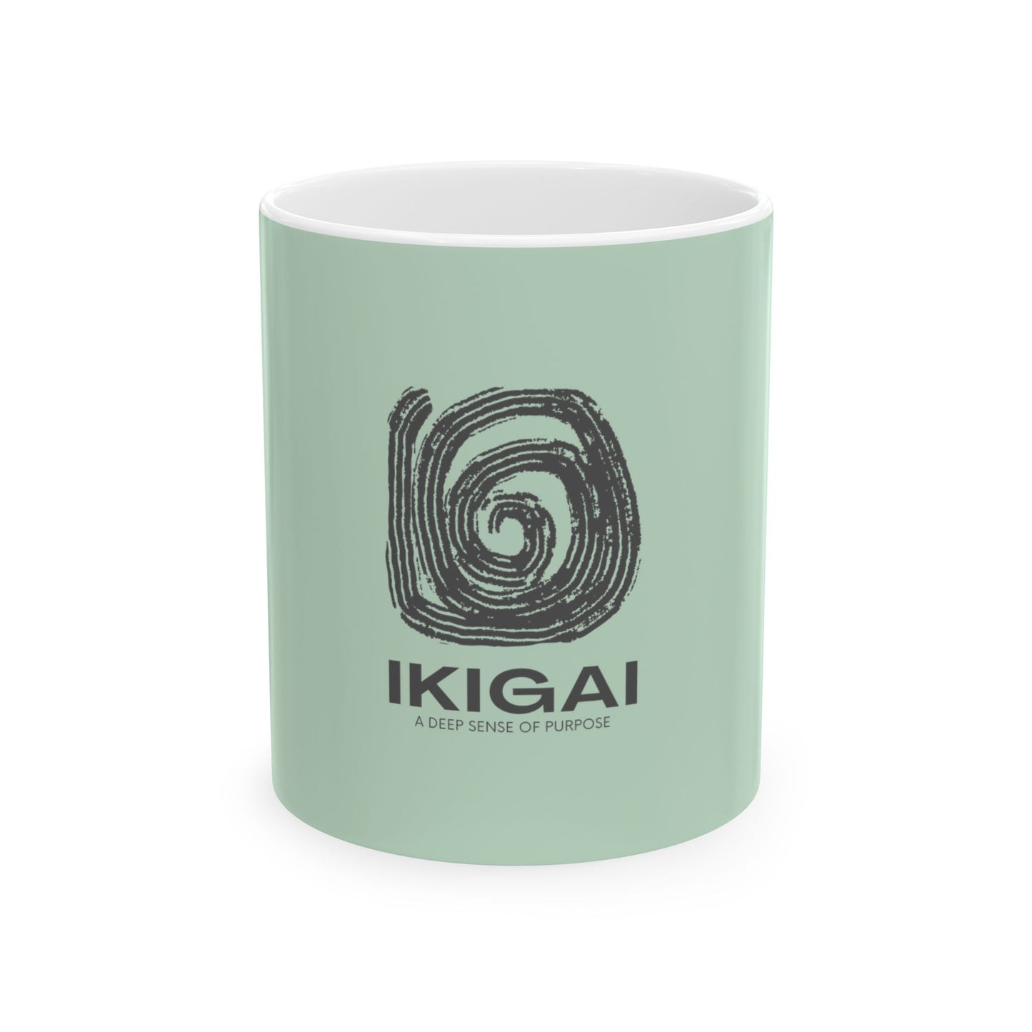 A mint green ceramic mug with a white interior, featuring a black spiral graphic and the text 'IKIGAI' and 'A DEEP SENSE OF PURPOSE' printed on the front, set against a plain white background.