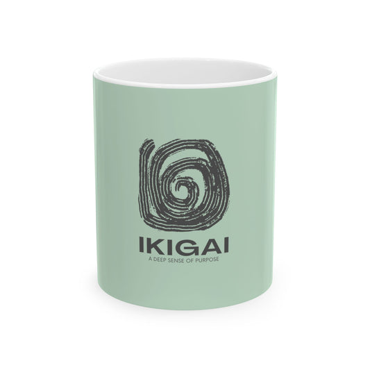 A mint green ceramic mug with a white interior, featuring a black spiral graphic and the text 'IKIGAI' and 'A DEEP SENSE OF PURPOSE' printed on the front, set against a plain white background.