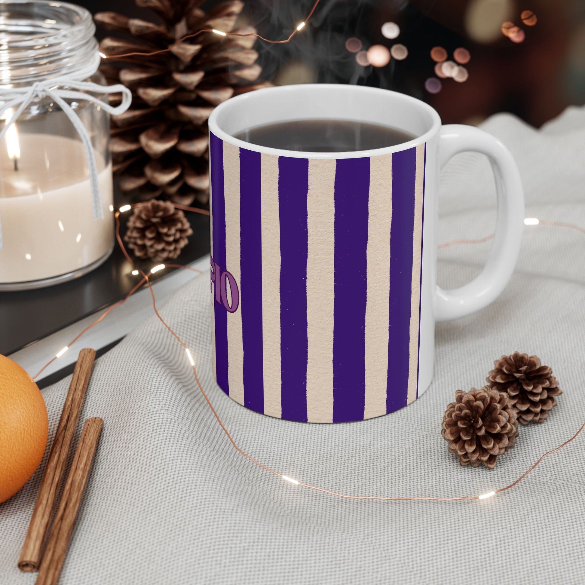 Mug with purple and beige stripes on a table with decorative items