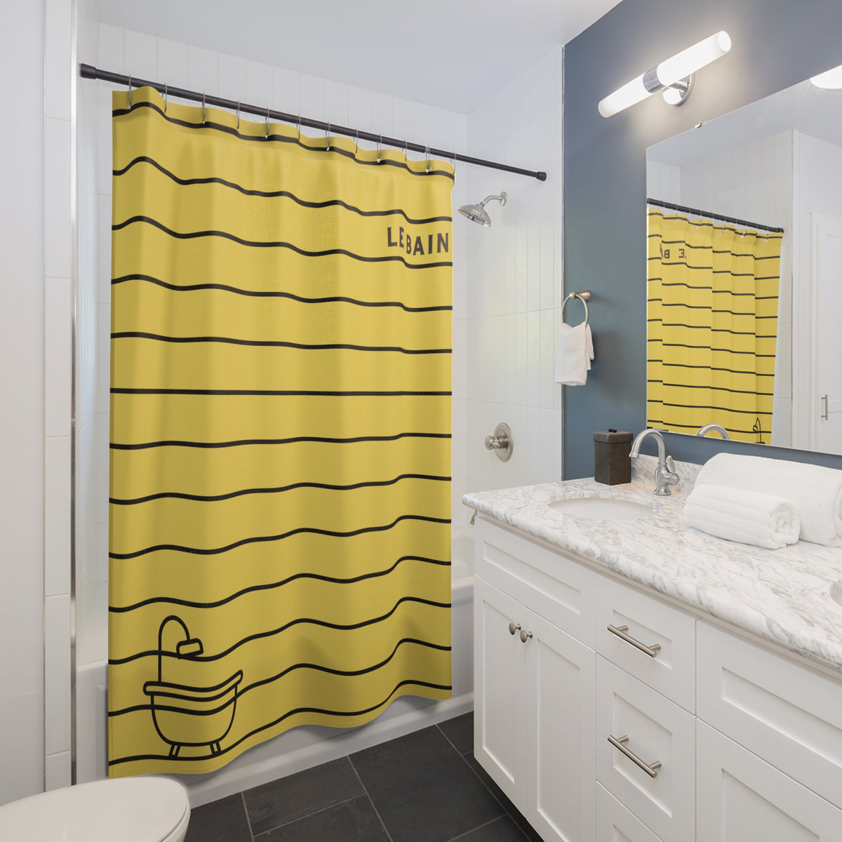 A yellow fabric shower curtain with black horizontal stripes, featuring the word 'LISAIN' and a small bathtub outline near the bottom, shown hanging in a modern white bathroom with a marble vanity and dark gray tile floor.