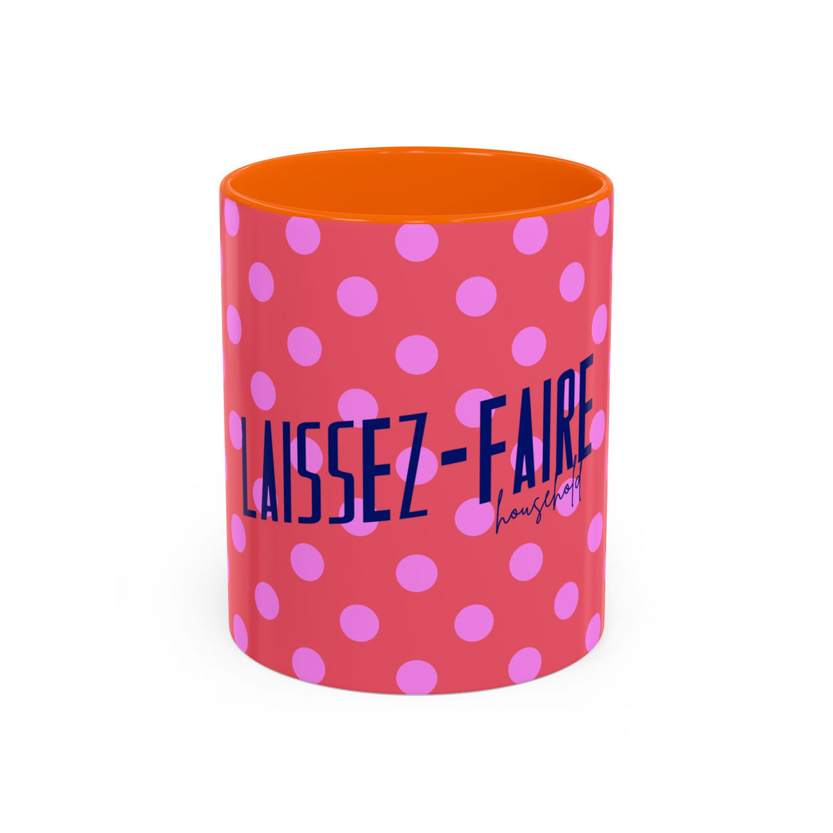 A cylindrical mug with a coral pink exterior patterned with light pink polka dots, featuring the text 'LAISSEZ-FAIRE housing' in navy blue. The interior of the mug is bright orange, and the mug is photographed on a clean white background.