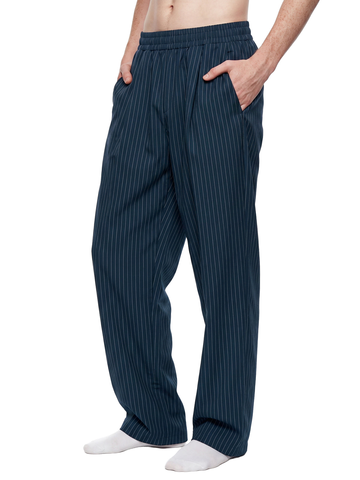 A person wearing dark navy pinstriped lounge pants with white socks, shown from the waist down against a plain white background.