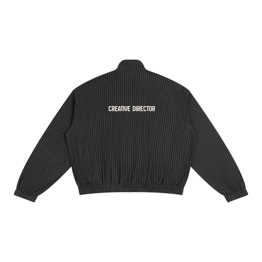 A black pinstriped bomber jacket shown from the back, featuring a large white graphic of CREATIVE DIRECTOR across the upper back.