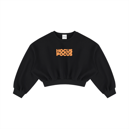A black cropped crewneck sweatshirt with 'HOCUS POCUS' printed in orange across the chest, displayed flat against a solid white background.