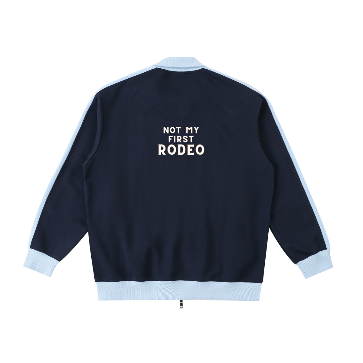 A navy blue bomber jacket shown from the back, featuring light blue ribbed trim on the collar, cuffs, and hem, with white text reading 'NOT MY FIRST RODEO' printed on the upper back.